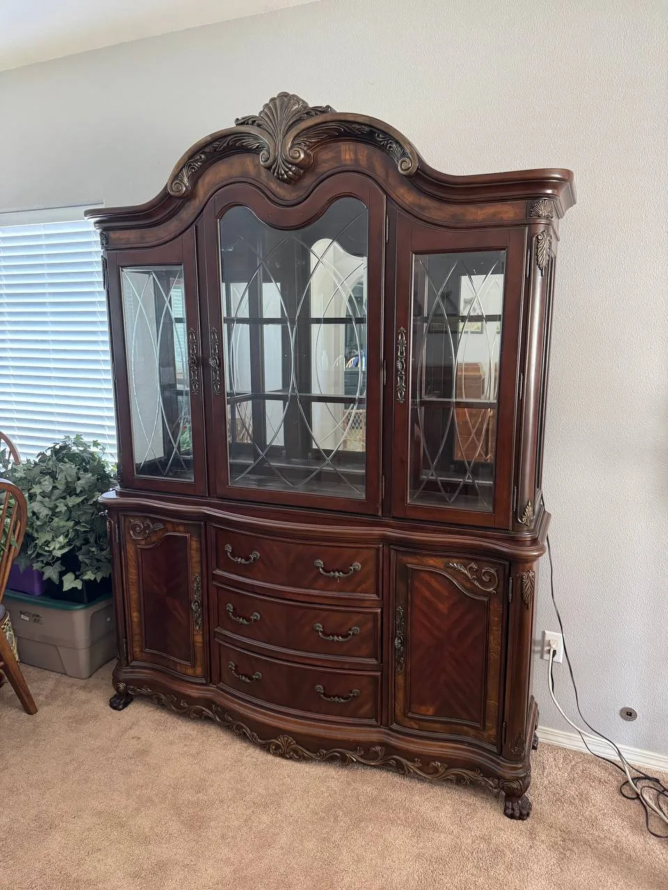 An antique china cabinet with glass doors before a move