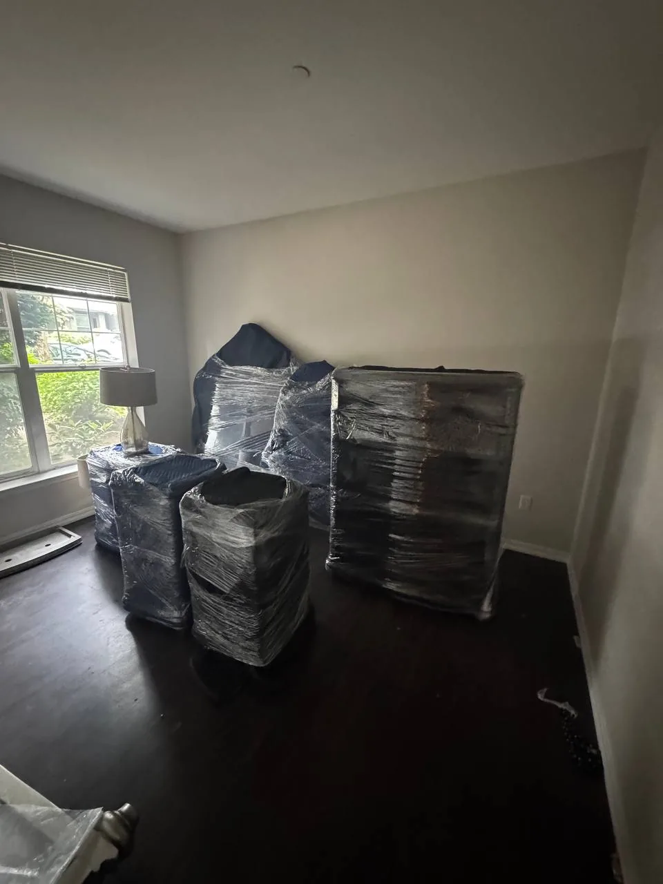 Furniture shrink wrapped and staged in an empty bedroom