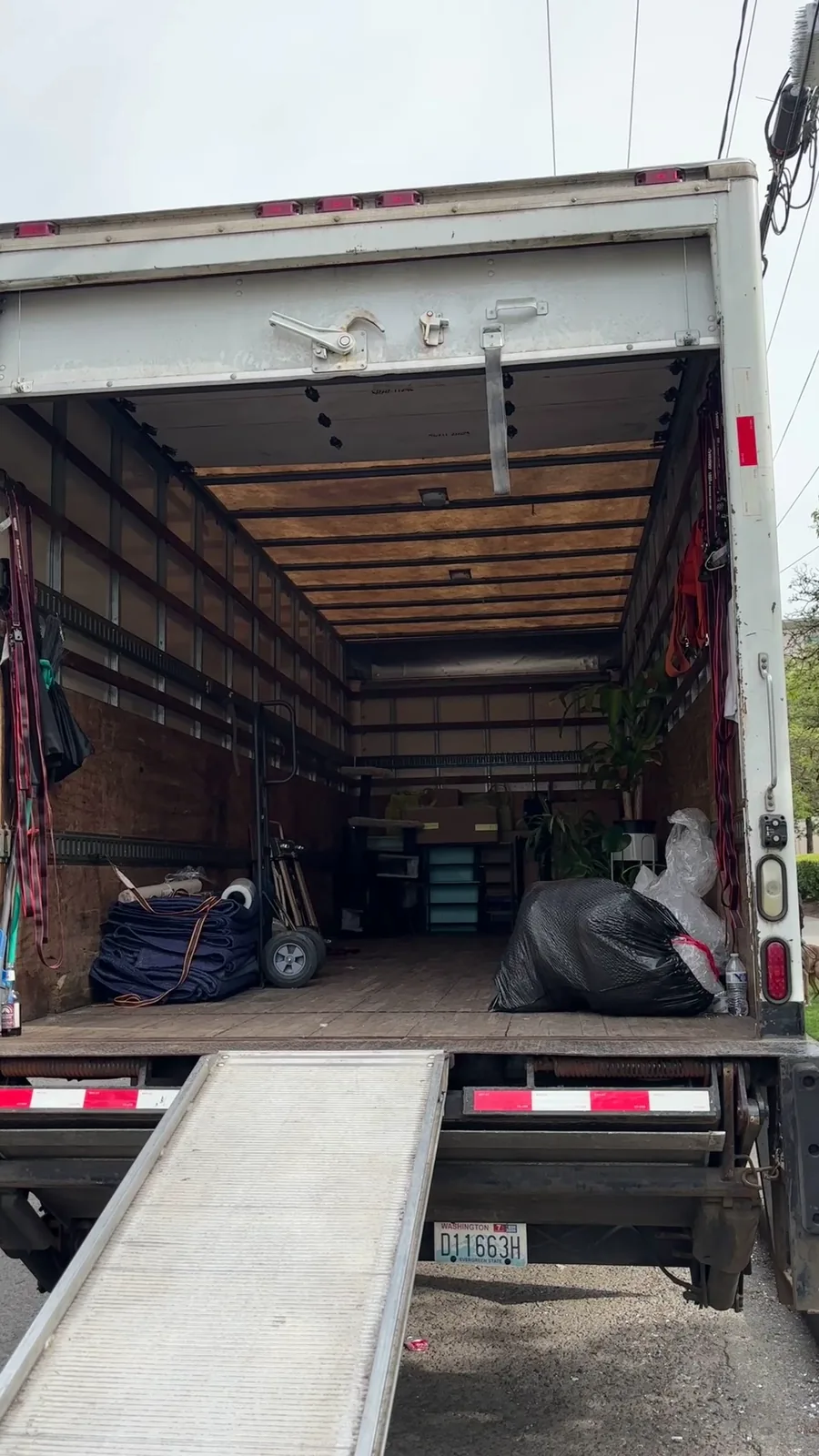 The back of a moving truck with the door open and the ramp down